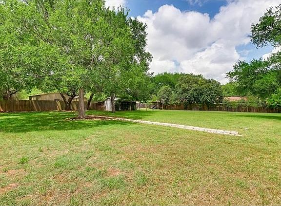 heavily treed, fully fenced yard, storage shed and covered dog run