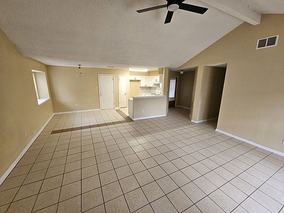 Family/Living Room looking towards kitchen and dining area and garage door, front door and hallway to bedrooms