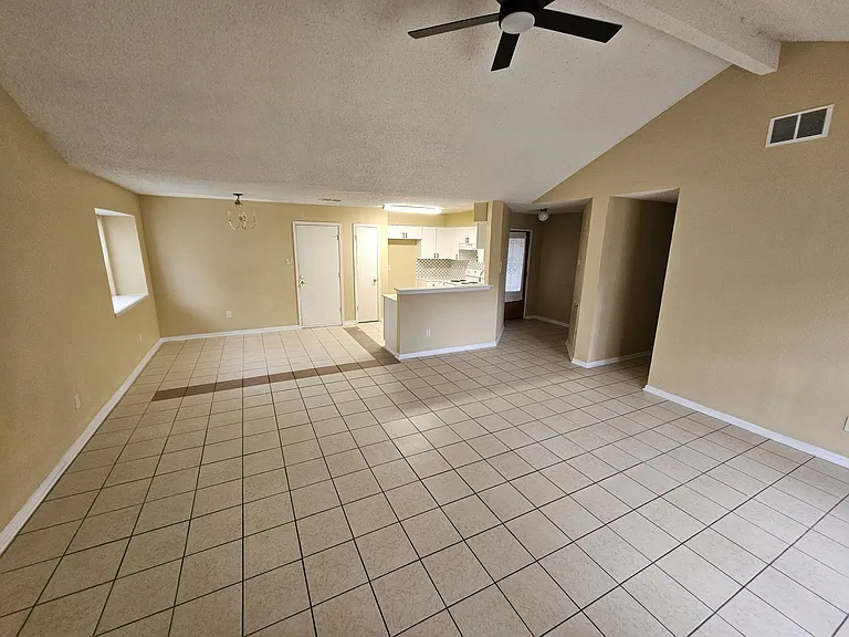 Family/Living Room looking towards kitchen and dining area and garage door, front door and hallway to bedrooms