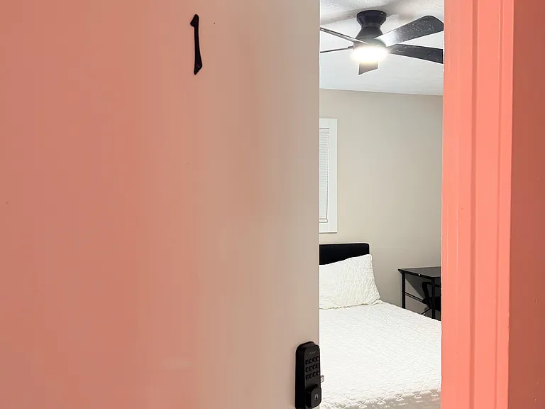 Private bedroom featuring a ceiling fan, a window with blinds, and space for a bed plus a small desk or nightstand.