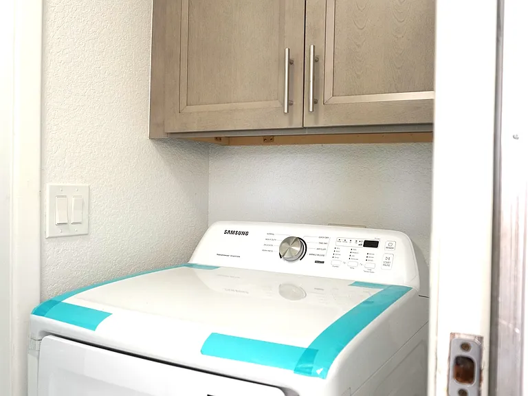 dryer in laundry room between kitchen and garage