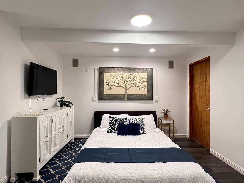 Queen size bed, dresser, and bathroom door.