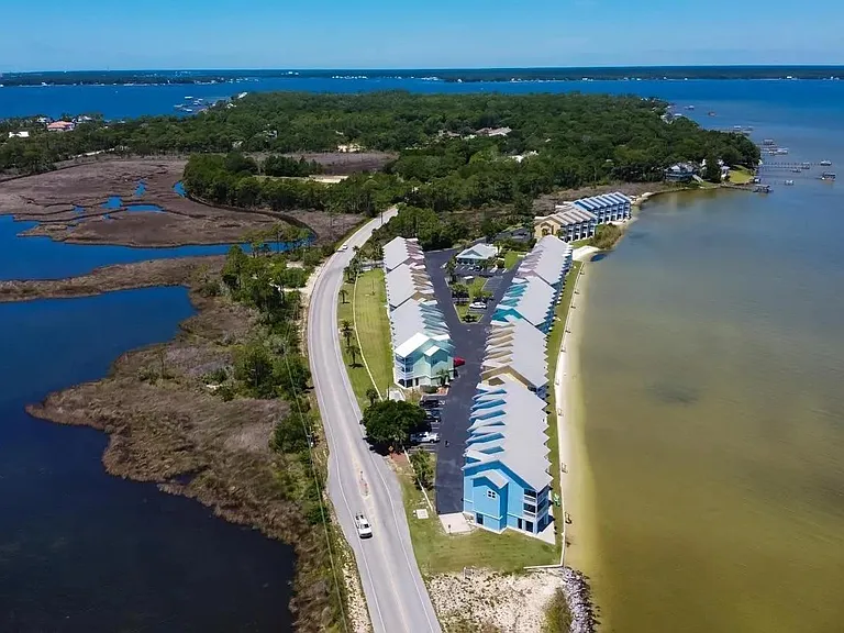 The community sits on a narrow peninsula where Perdido Bay shimmers to the north, while the Intracoastal waterway flows to the south offering a dynamic waterway backdrop.