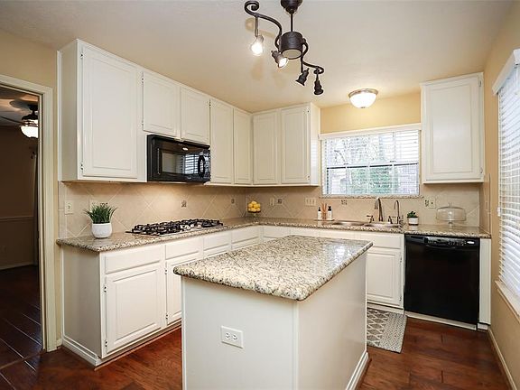 The kitchen features beautiful cabinets and gorgeous granite counters.