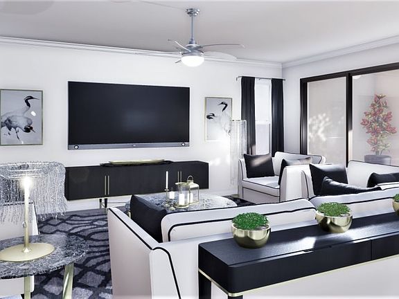 The expansive family room is bathed in natural light from sliders that open to the nearby lanai crea