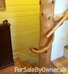 Hand turned railing leads to 2nd floor
						:
						Spruce log supporting post from the property. All walls and ceilings are wood