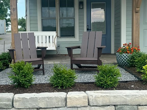 Front patio with two adirondack chairs with lake views and a daybed swing