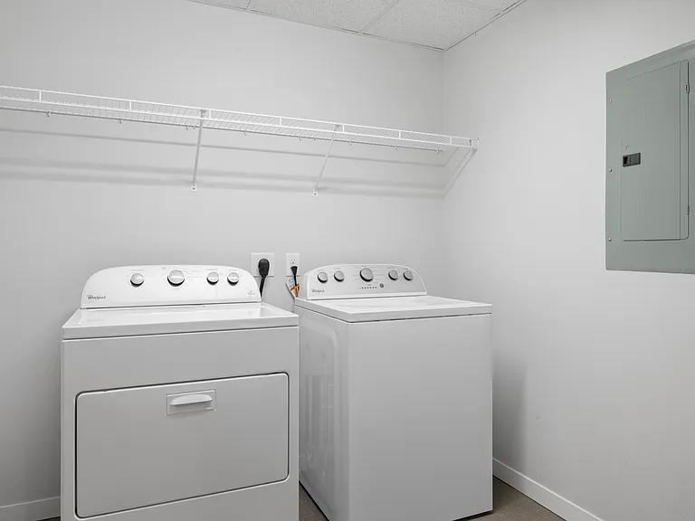 Modern laundry room with energy-efficient washer and dryer, featuring ample shelving for organization. Modern laundry room with energy-efficient washer and dryer, featuring ample shelving for organization.