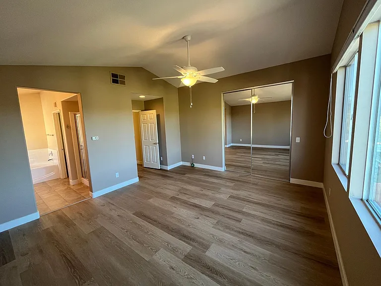Spacious master bedroom with en-suite bath, walk in closet, and vaulted ceilings.
