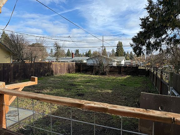 car access through gate. Lights on fence around the yard. Large wine grape wine in yard and blackberries.