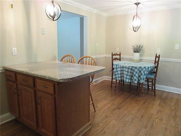 This is the kitchen/dining area, which has been updated with new hardwood floors and lighting, and features a chair rail, and crown molding.