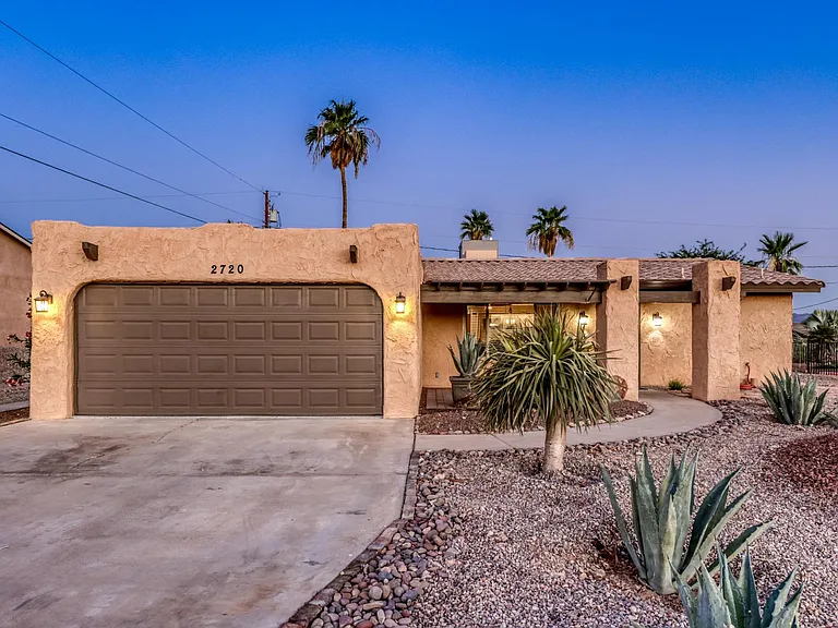 Deep two-car attached garage with spacious driveway parking.