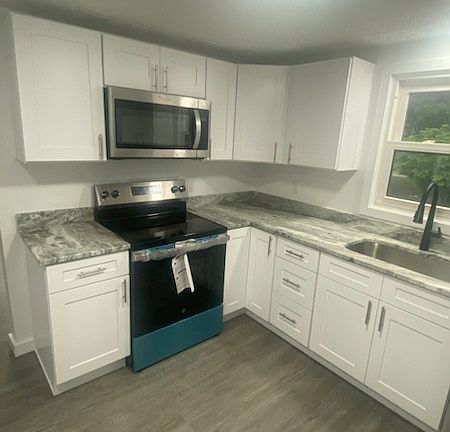 updated kitchen with new appliances, soft close cabinets, quartz tops and disposal