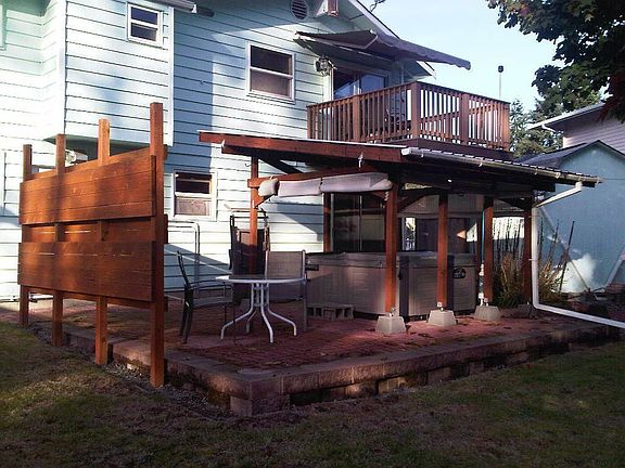 The back of the house with the awning on the upper deck mostly extended.