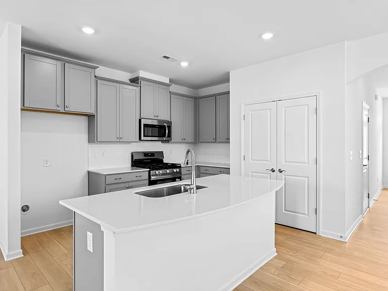 Kitchen Area View- Cabinets and Double Pantry Doors Provide Ample Storage Space