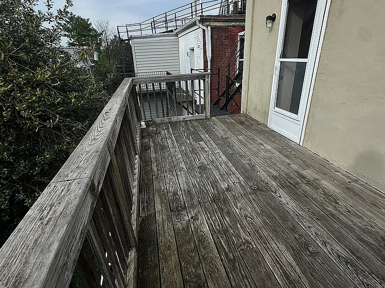 spacious deck overlooking the yard with a fire escape staircase