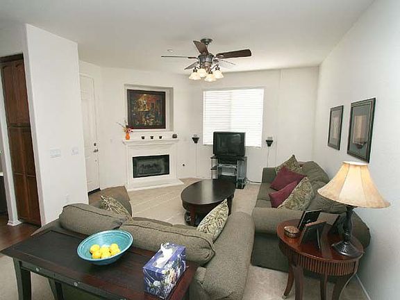 Living room with ceiling fan and fireplace