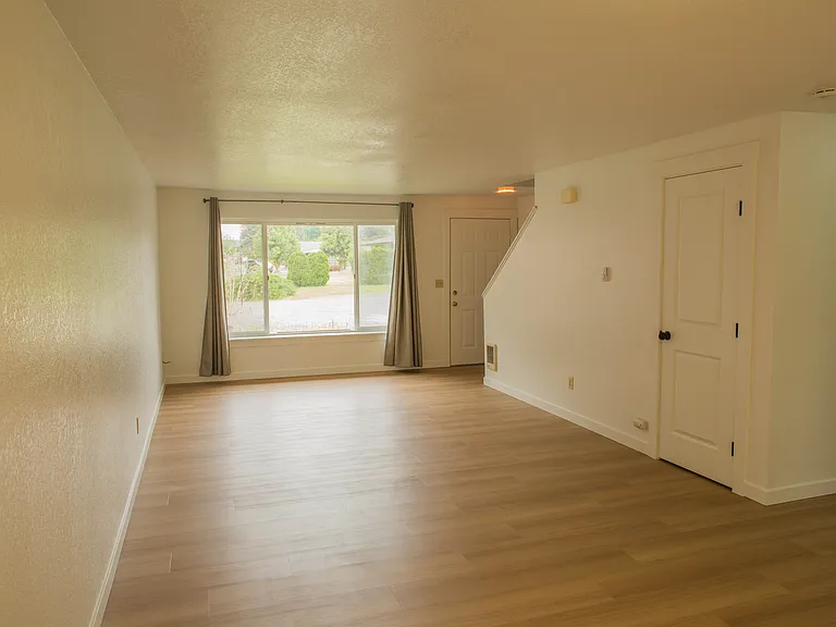 Front yard and entry area with mature landscaping, peaceful surroundings, and a spacious residential setting.