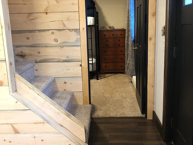 Bunk room. Has two bunk beds, a dresser and hooks.