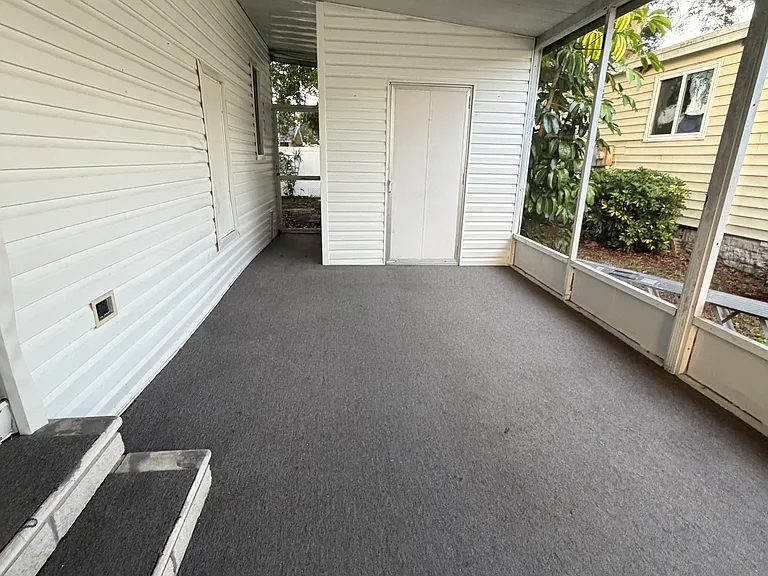 Screened Florida room with built in shed - back door to the private fenced back yard with additional storage room/workshop