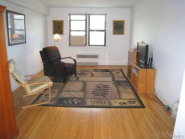 Sunny Living Room with refinished hardwood floors. Room size is 19'-2" x 12'-0"