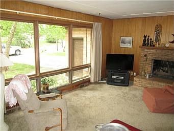 Living Room w/ Large Windows & Masonry Fireplace
