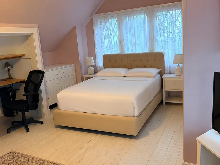 Furnished upstairs bedroom with natural light and flexible living space.