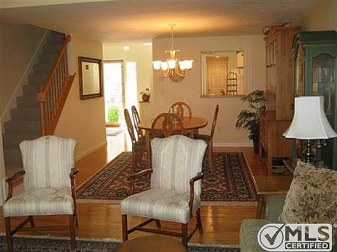 Dining on gleaming hardwood floors. Stairs leading to guest suite and large loft.