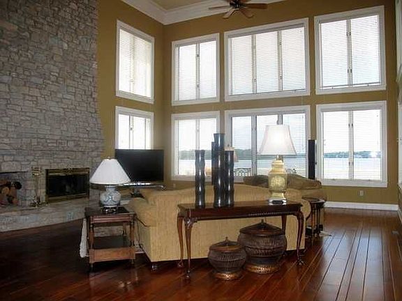 Has 22' Ceilings, Hardwood Floors, Wet-Bar, & opens to Wrap around Wood Deck.