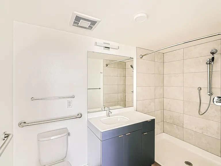 Relax in this modern bathroom at Anker Ballard, featuring a bathtub, vanity, and elegant design elements that create a serene atmosphere.