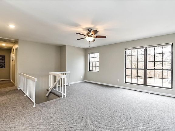 Living Room windows overlook wooded common ground across the street.