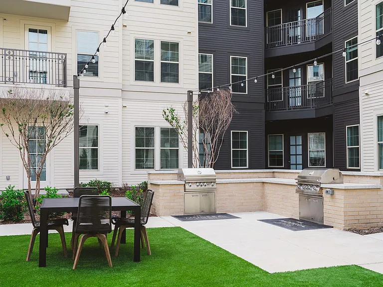 Outdoor courtyard with grilling areas and lounge seating