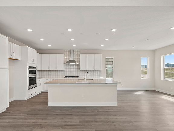 Gourmet kitchen and dining with laminate hardwood flooring