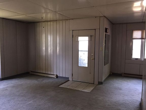 Living room with front door, dining room on right