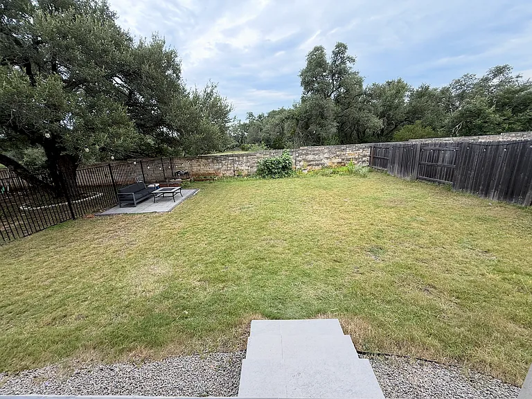 Large fenced backyard with patio area