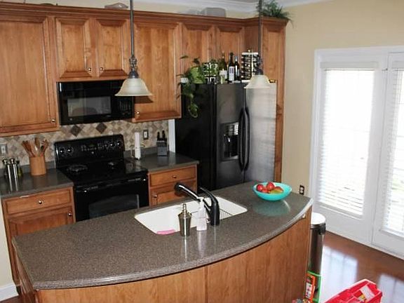 Kitchen island with dual sink, solid surface and pendant lighting. New refrigerator as of December, 2018 (not pictured here). Kitchen pantry with shelving and half-bath just steps away