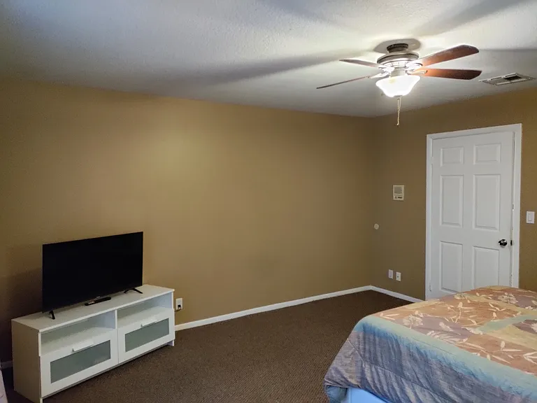 Upstairs back bedroom with private balcony.