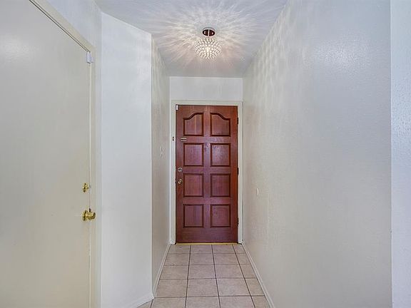 Front entry with tiled floor, beautiful light fixture and neutral colors.