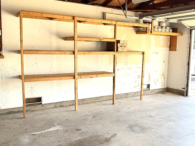 Lots of shelving in garage for storage. More shelving on each wall.