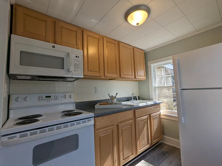 New microwave and refrigerator in kitchen.