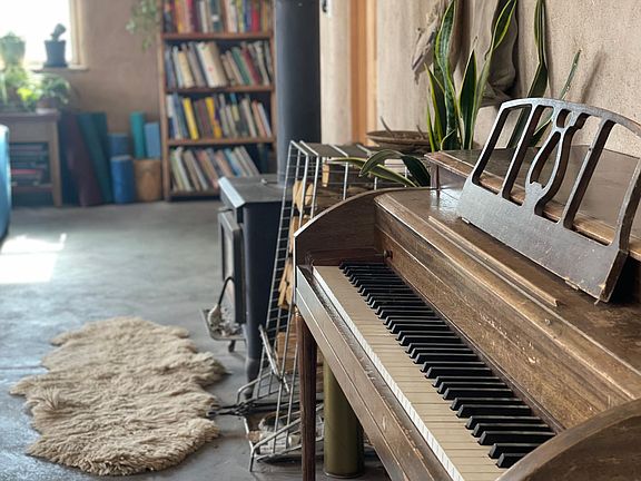 Piano detail. Yoga equipment shown in rear.