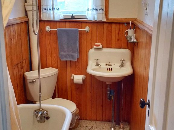 Upstairs bath with clawfoot tub and shower extension. You'll be pleased that we stripped the pink paint off of the beautiful original wood.