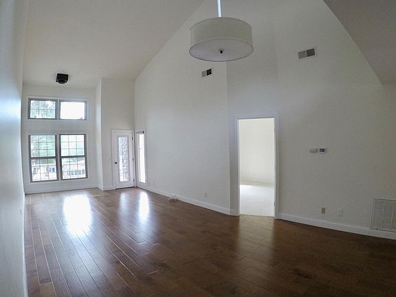 Living room and dining area with wood floors and vaulted ceilings