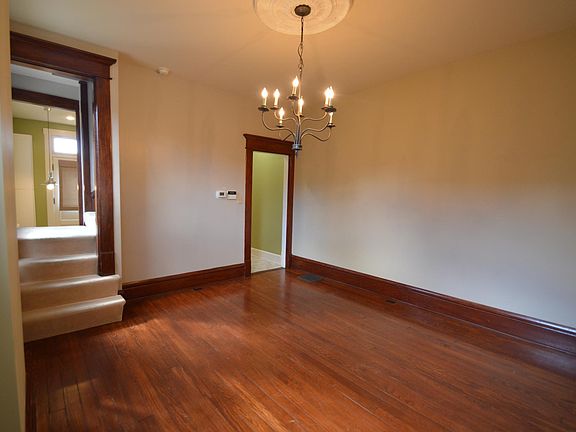 Dining room with chandelier lighting and original wood floors.