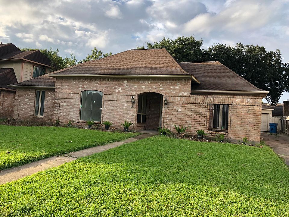 Front view with long drive-way leading to garage