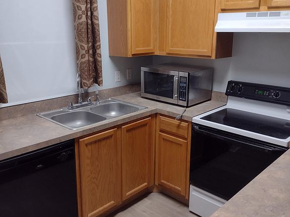 Kitchen includes a dishwasher, garbage disposal, microwave, oven/stove, and range hood.
