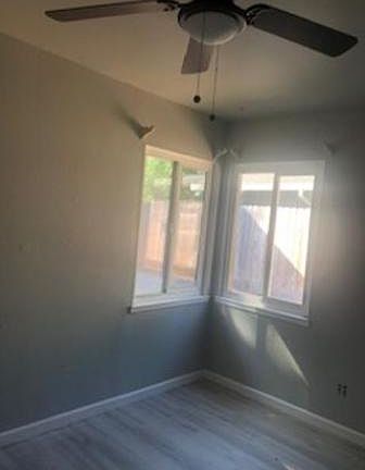 Bedroom with new grey paint, new fan light and new grey laminate floor.