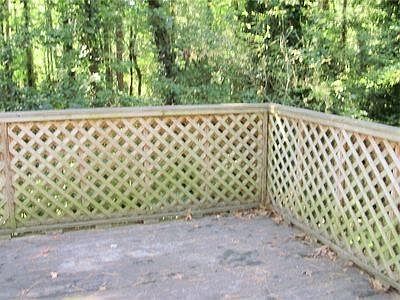 Deck overlooking fenced back yard and hardwood trees
