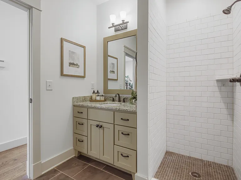 Bathroom 2 includes a vanity with storage for toiletries, and a standing tiled shower.