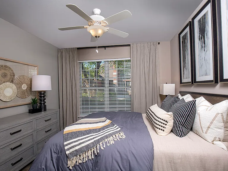 Bedroom with large window and ceiling fan